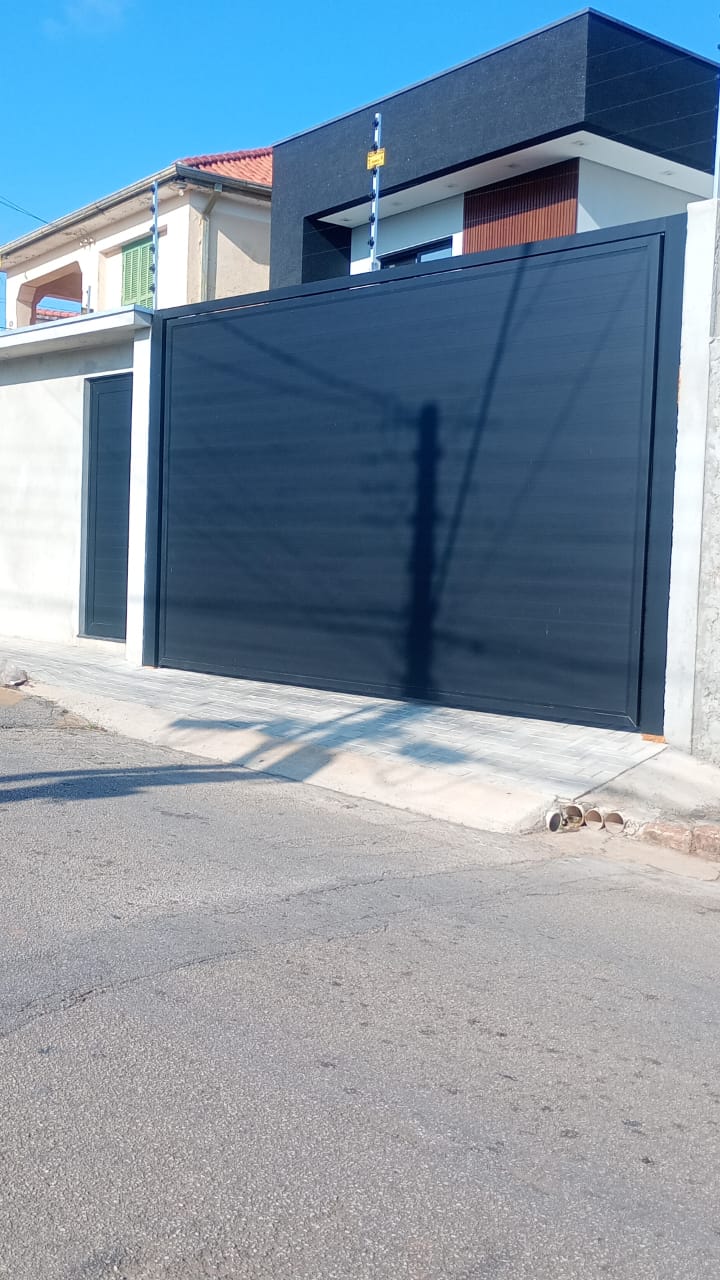 Portão de alumínio preto basculante instalado em residência